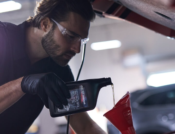 Service Technician Pouring Oil